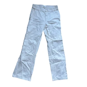 Vita cargopants - Snygga vita cargopants med raka ben och flera praktiska fickor på sidorna och bak. Byxorna har bälteshällor och klassisk dragkedja framtill. Perfekta för en avslappnad och trendig look.