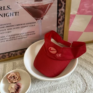 Röd Nike visorkeps med broderi - Snygg röd visorkeps från Nike med broderad logga och bokstäverna EK framtill. Justerbar rem baktill för perfekt passform. Kepsen är tillverkad i mjuk bomull och har en klassisk, sportig look som passar dig som gillar att sticka ut.