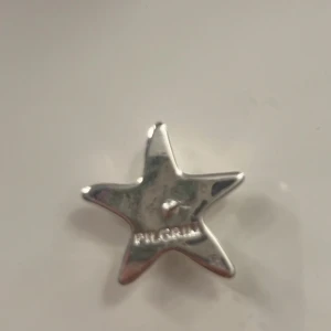 Stjärnformade örhängen från Pilgrim - Snygga örhängen i form av stjärnor från Pilgrim. De är i blankt silverfärgat material och har en cool, modern design som verkligen sticker ut. Perfekta för dig som vill ha något unikt och trendigt i smyckeskrinet.