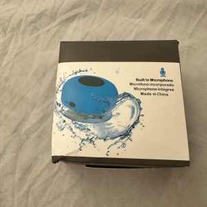 Vattentät Bluetooth-högtalare med mikrofon - Kompakt, vattentät Bluetooth-högtalare med inbyggd mikrofon. Upp till 4 timmars batteritid, IPX4-klassad, 3W uteffekt och handsfree-funktion. Kompatibel med mobil, surfplatta och dator. Oöppnad förpackning, lätt skadad kartong.