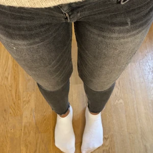 Grå skinny jeans med slitningar - Säljer ett par grå skinny jeans med snygga slitningar och råa benslut. Jeansen är i stretchigt denim som sitter tight hela vägen ner. Perfekta för dig som gillar en smal siluett och vill ha en cool, avslappnad look.
