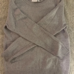 Grå stickad tröja från Vila - En enkel grå stickad tröja från Vila i storlek M. Använd en del och en svag röd fläck på framsidan. Säljer eftersom den inte kommer till användning💗
