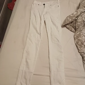 Vita skinny jeans med fem fickor - Snygga vita jeans med klassisk femficksdesign och smal passform. Byxorna har normal midja och är tillverkade i ett stretchigt bomullsmaterial för extra komfort. Perfekta för dig som vill ha en clean och fräsch look.
