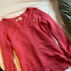 Rosa stickad tröja från Hollister - Säljer en rosa stickad tröja från Hollister med v-ringning och lång ärm. Den är vintage och säljs alltså inte längre. Den är storlek large men sitter bra på mig med XS, bara lite mer pösigt, men det funkar verkligen.