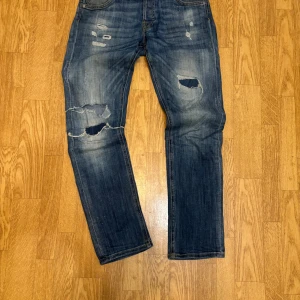 Straight fit jack n jones jeans - Säljer ett par väldigt feta och unika jack and jones jeans i storlek 29/32. Jeansen är mer åt de straight hållet så inget för dig om du söker en skinny look. Slitningarna är hemmagjorda och väldigt unika, vid frågor/funderingar är de bara att skriva.