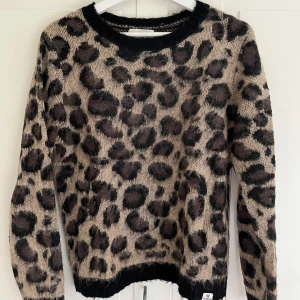 Leopardmönstrad stickad tröja - Stickad tröja i leopardmönster från Systemaction. Knappt använd och därmed i princip nyskick. Storlek M men känns som storlek S. Nypris 770kr. 