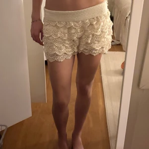 Beige spets-shorts från Wannabes - Säljer ett par beige shorts från Wannabes Collection med bred resår i midjan och vacker spets med volangdetaljer. Jag brukar vika ned kanten så att de blir lågmidjade (på bilden är den nedvikt!!) 💕 Står inte storlek men jag har vanligtvis S/M💕💕