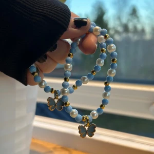 armband med fjärilsberlock 🦋 - 39 kr/per armband 🩵 armband med pärlor i blått och vitt, dekorerade med guldiga detaljer och söta fjärilsberlocker. Perfekt för att ge en extra touch till din outfit. Tillverkade med dubbla elastiskatrådar för säkerhet!