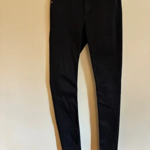 Skinny jeans från Tiger of Sweden - Mörkt blå skinny Jeans. Väldigt sparsamt använda. Storlek 28 i midjan och 34 i benen.  Stretchiga och mjuka i tyget 