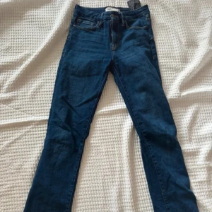 Mörkblå bootcut jeans från Zara - Snygga mörkblå bootcut jeans från Zara med klassisk femficksdesign och normalhög midja. Jeansen är tillverkade i stretchigt denim för en tight och bekväm passform. Perfekta för dig som gillar en stilren och enkel look.