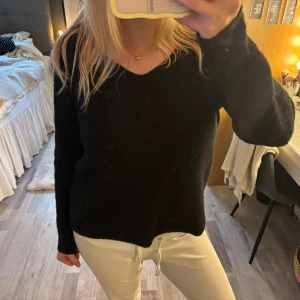 Svart stickad tröja från Pieces - Mysig svart stickad tröja från Pieces i strolek M med v-ringad hals och lång ärm. Tröjan har en enkel och stilren design som är lätt att matcha. 