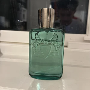 Parfums de Marly Greenley 125ml - Greenley från Parfums de Marly, 125ml Eau de Parfum. Snygg flaska och box med unikt designad logga. Tillverkad i Frankrike. Perfekt för dig som vill sticka ut med en exklusiv doft. Det är ungefär 100ml kvar på den och den kommer med originella lådan för parfymen