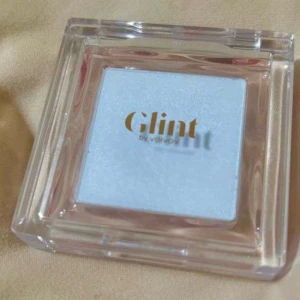 Glint ljusblå highlighter och blush 2 in 1  - Superfin highlighter från Glint i en frostig ljusblå nyans. Kommer i en stilren, transparent fyrkantig dosa. Ger en skimrande, kall glow på huden och passar perfekt för att skapa en unik look med extra lyster.
