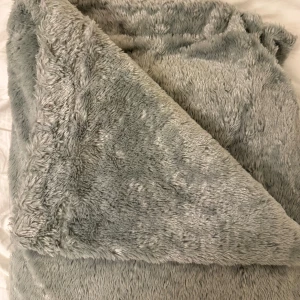 Grå fluffig filt från hemtex - Supermjuk och stor grå filt från hemtex tillverkad i 100% polyester. Den har en fluffig och gosig yta. Perfekt nu till hösten eller som julklapp 