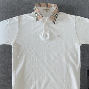 Burberry - Vit pikétröja från Burberry i storlek S. Den är I mycket bra skick, hör av dig vid frågor!