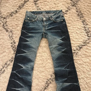 Weekday Nova Low Slim Bootcut Jeans - Snygga blå bootcut jeans från Weekday i modellen Nova Low Slim. Jeansen har låg midja, klassisk femficksdesign och coolt mönster. 