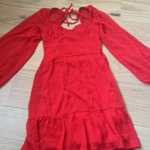 Röd kort klänning från H&M Divided perfekt för jul och vinter❤️ - Supersöt röd kort klänning från H&M Divided med långa puffärmar, knytning i ryggen och volang nertill. Tunt, lätt material med diskret prickigt mönster och markerad midja. Perfekt för dig som gillar färg och romantiska detaljer.