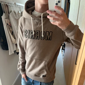 Morris hoodie  - Tjenare, säljer en beige hoodie från Morris. Skicket är väldigt bra, skulle säga 9/10. Storleken är M, killen på bilden är 180 cm. Släng iväg ett dm för frågor! 🍾💯
