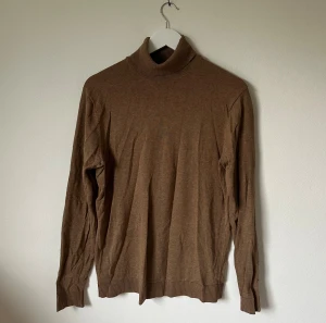 Brun polotröja från Selected Homme - Snygg brun polotröja från Selected Homme i storlek M. Tröjan har en klassisk polokrage och är tillverkad i mjuk bomull med ribbade muddar vid ärmslut och nederkant. Perfekt för dig som gillar stilrena och enkla plagg med skön passform. 4Ä14