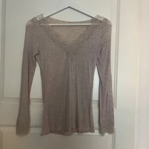 Beige intimissimi topp - Superfin beige långärmad topp med v-ringning och spetsdetaljer både vid halsringningen och ärmsluten. Tunn och mjuk i materialet. Använd 3/4 gånger så den är i väldigt fint skick. Nypris 539kr 🤍 