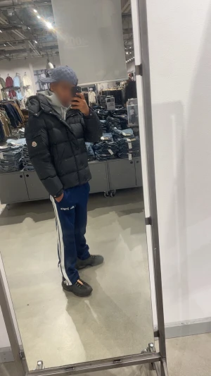 Svart Moncler pufferjacka herr - Säljer en svart pufferjacka från Moncler med klassisk logga på ärmen. Jackan har en clean design med stora quiltade partier, dragkedja och knappar framtill. Perfekt för kalla dagar och riktigt snygg . Fodrad och med hög krage för extra värme. För fler bilder kom till chatten. Pris kan diskuteras 