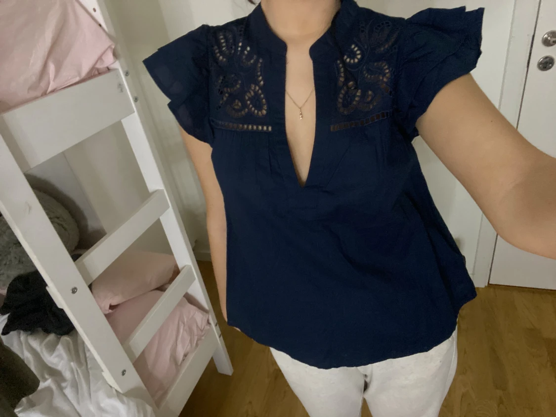 Mörkblå blus med volangärm och broderi