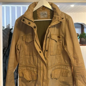 Safari jacka beige peak performance - Snygg peak jacka. Inbyggd luva