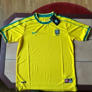 Brasilien VM 1998 tröja. Storlek M - En klassisk/retro Brasilien fotbollströja från VM 1998 i storlek M. Passar perfekt både på fotbollsplanen men också utanför plan för den som gillar street stil.