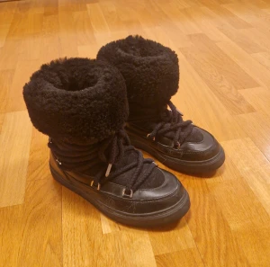 Inuikii - Säljer ett par fina svarta Inuikii Classic high vinterskor. Ett par varma och sköna fårskinnsfodrade boots i skinn och mocka. ✨️