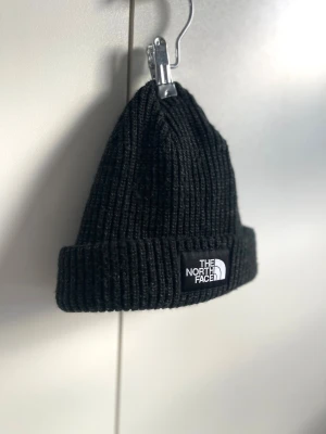 Svart ribbstickad mössa The North Face - Onesize-Regular. Unisex. Aldrig använd. 🖤  ”Salty Dog BeanieThe North Face® Salty Dog mössan kombinerar lager med värme med en klassisk industristil. Akrylmössan är jerseyfodrad för komfort. En medellång passform gör att den kan bäras åtsittande runt huvudet. The North Face® loggan vilar på mudden som kan vikas upp eller ned.”  Skickas inom 24h. 💌
