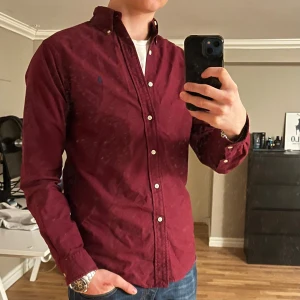 Ralph Lauren - Tja! Säljer en riktigt snygg Morris skjorta. Den är i väldigt bra skick 9/10. Skjortan är i färgen vinröd. Märket är navy. Storlek S kan passa M. Den är perfekt i alla tillfällen men speciellt nu på hösten 🍂 Nypris runt 2000 kr Hör av dig vid funderingar🙌