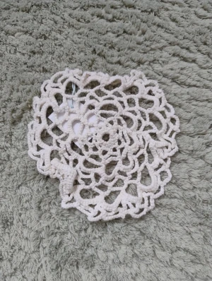 Handgjord virkad duk - Säljer en handgjord virkad liten duk i bomull. Duken har ett coolt mönster med hål som liknar en blomma.