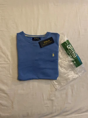 Ljusblå  stickad tröja Polo Ralph Lauren - Säljer en jätte snygg crewneck ifrån Ralph Lauren. Den är i toppen skick med inga hål. Skriv till mig vid intresse❤️ Obs påsen tillkommer inte 