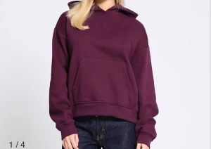 Vinröd hoodie med huva - Säljer en vinröd hoodie med huva och stor magficka. Tröjan har en loose passform och är tillverkad i mjuk bomull, perfekt för chill dagar. Långärmad modell med ribbade muddar vid ärmslut och nederkant. Enkel och stilren design. Nypris: 200kr