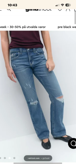 Blå bootcut jeans med slitningar - Snygga blå jeans från Gina Tricot med raka ben och coola slitningar på knä och lår. Klassisk femficksmodell med knappstängning och detaljerade bakfickor med lock. Perfekt för dig som gillar en avslappnad och trendig look.