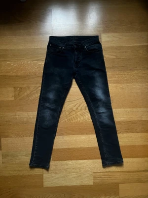 Nudie Jeans, 28/30, Svart, Bra Skick - Tja! Säljer ett par snygga och klassiska jeans från Nudie Jeans, då de har blivit för små. Jeansen är gjorda av bomull, använda flera gånger och i bra skick. Perfekta till både vardag och lite mer uppklätt. Mvh William