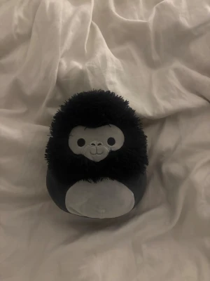 Squishmallows gorilla plush - Supermjuk och gosig Squishmallows gorilla i fint skick. Perfekt som present eller samlarobjekt! Inga synliga defekter eller slitage, originaletikett finns kvar. Passar både barn och vuxna som älskar mjuka gosedjur.
