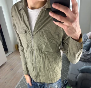 Tunn Olivgrön Fieldjacket  - Stilren och perfekt med hoodie eller tjocktröja under! Mått: A:53cm B:45cm C:50cm D:60cm. Skriv vid fundering 😇