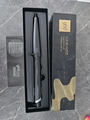 GHD Curve Wand Creative Curl - Snygg svart locktång från ghd, modell Curve Wand Creative Curl. Konformad design för naturliga lockar och vågor. Ergonomiskt handtag och sladdfäste för enkel användning. Levereras i originalförpackning med instruktionshäfte. Endast använd 2 ggr. Nypris 2299sek