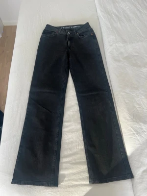 Svarta wide leg jeans - Snygga svarta jeans  med wide leg-modell och midrise midja. Klassisk femficksdesign och diskreta sömmar. Perfekta för dig som gillar en avslappnad och trendig stil.