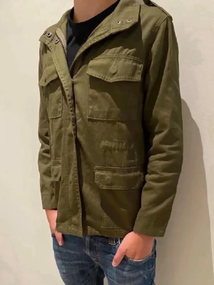 Olivgrön overshirt - Jackan har dragkedja och knappar. Hör av dig vid minsta fundering. 