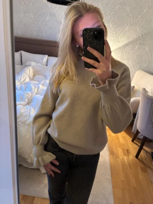 Stickad tröja med snygga ärmar - Fin beige stickad tröja med trumpetärmar. Tröjan har en avslappnad passform och enkel att matcha med jeans🤍