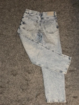 Ljusblå acid wash Bershka jeans  - Säljer ett par ljusblå acid wash jeans från Bershka. 29/30 Klassisk femficksmodell med bälteshällor och knappgylf. Jeansen är tillverkade i bomull och har en retro 90-talsvibe som är supertrendigt just nu. 