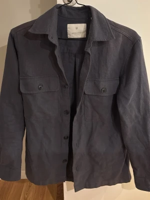 Mörkblå overshirt från Jack & Jones - Stilren mörkblå overshirt från Jack & Jones. Storlek xs men sitter som s. Helt oanvänd så inga defekter mm. 