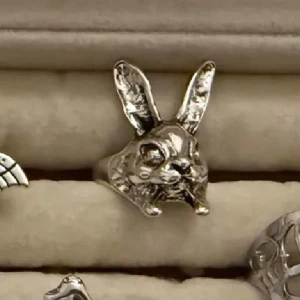 Silvrig ring med kaninform - Unik ring i silverfärgad metall med ett detaljerat kaninhuvud som motiv. Ringen har upphöjda öron och tydliga ansiktsdrag, vilket ger ett lekfullt och coolt uttryck. Perfekt för dig som gillar djur och vill sticka ut med dina accessoarer.