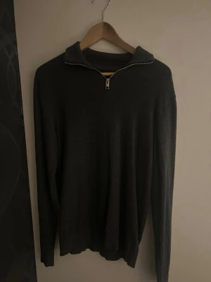 Mörkgrå half-zip tröja  - Mörkgrå stickad tröja med halv dragkedja vid kragen. Bra skick. Storlek S. Passar en fredag kväll.