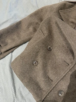 Kort kappa Gina tricot - Aldrig använt, nyskick. Storlek xs passar xs-s. Mjuk å gosig , jättefin men har för många jackor. Beige/brun kort kappa från Gina tricot