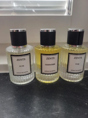 3x bundle zents parfym - Tre exklusiva parfymflaskor från Zents: Dusk, Godfather och Ivar. Flaskorna är genomskinliga med räfflad yta och svart lock med silverdetaljer. Godfather har en gul tonad vätska medan Dusk och Ivar är mer klara. Perfekt för dig som gillar stilrena och lyxiga dofter.       Dusk - inspirerad av YSL l'homme la nuit. Godfather inspirerad av Xerjoff Naxos. Ivar inspirerad av Creed Viking