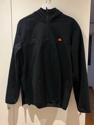 ellessee hoodie - svart tröja med huva samt dragkedja på ena sidan. OBS! gummit vid dragkedan framtill är lite skadat