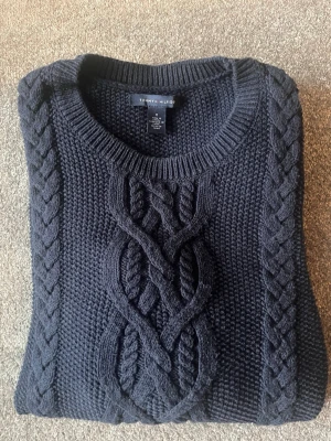 Mörkblå kabelstickad tröja Tommy Hilfiger, st. M - Mörkblå kabelstickad tröja från Tommy Hilfiger med grovstickat mönster och flätade detaljer framtill, storlek M. Rund halsringning och långa ärmar. Mycket bra skick!